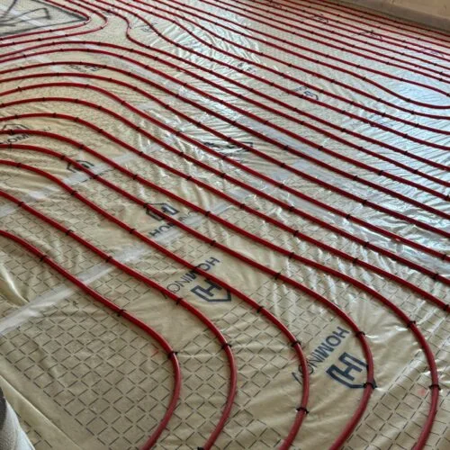 Installation des tubes de chauffage au sol avant coulage de la chape fluide thermique