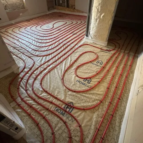 Réseau de tuyauterie pour sol chauffant contournant un poteau isolé en mousse expansive